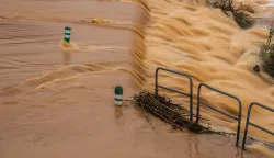 This photograph shows the overflowing of the Agly river flooding a road at the entrance of Rivesaltes in the Pyrenees-Orientales department in south-western France on December 26, 2025. Aude, Pyr?n?es-Orientales and Haute-Corse have been placed on orange alert for rain?flooding or floods by M?t?o-France until midnight on December 26, 2025. (Photo by Jean-Christophe MILHET/AFP)