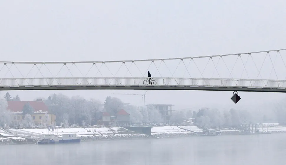 Osijek, 21. 01. 2026., Zimska reportaža, Sibirska fronta, zima, hladno vrijeme, snijeg, inje, ilustracija, pje&scaron;ački most, biciklistSNIMIO BRUNO JOBST