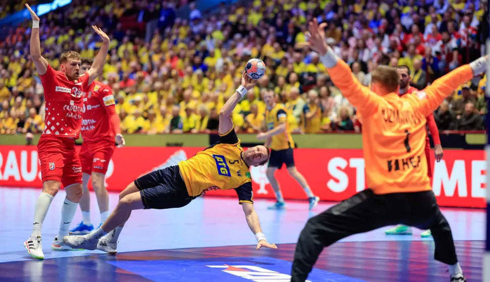 Sweden's pivot #05 Max Darj (C) scores during the men's EHF Euro 2026 Group E preliminary round handball match between Sweden and Croatia in Malmo, Sweden, on January 21, 2026. (Photo by Andreas Hillergren/TT/TT News Agency/AFP)/Sweden OUT