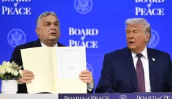 Hungary's Prime Minister Viktor Orban (L) holds a founding charter next to US President Donald Trump at the "Board of Peace" meeting during the World Economic Forum (WEF) annual meeting in Davos on January 22, 2026. US President Donald Trump will show off his new "Board of Peace" at Davos on January 22, 2026 burnishing his claim to be a peacemaker a day after backing off his own threats against Greenland. Originally meant to oversee the rebuilding of Gaza after the war between Hamas and Israel, the board's charter does not limit its role to the Strip, and has sparked concerns that Trump wants it to rival the United Nations. (Photo by Fabrice COFFRINI/AFP)