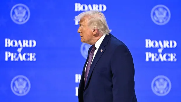 TOPSHOT - US President Donald Trump walks at the "Board of Peace" meeting during the World Economic Forum (WEF) annual meeting in Davos on January 22, 2026. US President Donald Trump will show off his new "Board of Peace" at Davos on January 22, 2026 burnishing his claim to be a peacemaker a day after backing off his own threats against Greenland. Originally meant to oversee the rebuilding of Gaza after the war between Hamas and Israel, the board's charter does not limit its role to the Strip, and has sparked concerns that Trump wants it to rival the United Nations. (Photo by Fabrice COFFRINI/AFP)