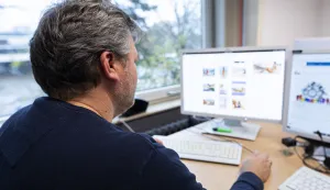 PRODUCTION - 29 November 2023, Lower Saxony, Hanover: Oliver Brockmann, chief inspector and investigator in the cybercrime/child pornography department of the State Criminal Police Office of Lower Saxony, sits in his office at the State Criminal Police Office of Lower Saxony in front of a monitor on which the interface of the "Tracebook KiPo" software developed by the LKA can be seen with demo photo files (posed scene). Photo: Michael Matthey/dpa Photo: Michael Matthey/DPA