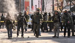 Federal agents stand near police tape as demonstators gather near the site of where state and local authorities say a man was shot by federal agents earlier in the morning in Minneapolis, Minnesota, on January 24, 2026. Minnesota Governor Tim Walz said Saturday that federal agents deployed in Minneapolis as part of a sweeping immigration crackdown had carried out "another horrific shooting," less than three weeks after the fatal shooting of Renee Good. (Photo by ROBERTO SCHMIDT/AFP)