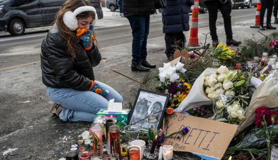 A local resident kneels as she cries while visiting a makeshift memorial in the area where Alex Pretti was shot dead a day earlier by federal immigration agents in Minneapolis, Minnesota, on January 25, 2026. On January 24, federal agents shot dead US citizen Alex Pretti, a 37-year-old ICU nurse, while scuffling with him on an icy roadway, less than three weeks after an immigration officer shot and killed Renee Good, also 37, in her car.His killing sparked new protests and impassioned demands by local leaders for the Trump administration to end its operation in the city. (Photo by ROBERTO SCHMIDT/AFP)