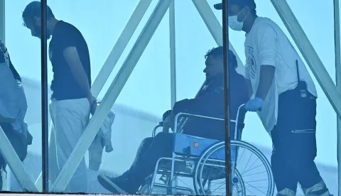 A Venezuelan migrant deported from the United States arrives in a wheelchair at Simon Bolivar International Airport in Maiquetia, Venezuela on January 19, 2026. (Photo by Juan BARRETO/AFP)