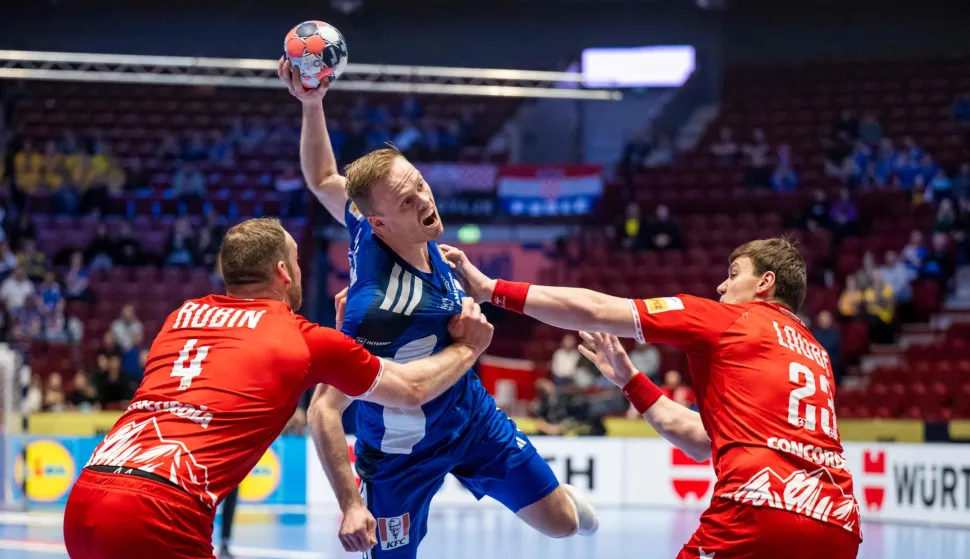 Iceland's right back #14 Omar Magnusson (C), Switzerland's left back #04 Lenny Rubin (L) and Switzerland's pivot #23 Lukas Laube (R) vie for the ball during the men's EHF Euro 2026 main round handball match Switzerland v Iceland in Malmoe, Sweden, on January 27, 2026. (Photo by Johan NILSSON/TT NEWS AGENCY/AFP)/Sweden OUT