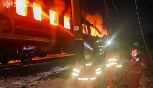 In this handout photograph taken and released by the Ukrainian Emergency Service on January 27, 2026, Ukrainian medics stand next to a burning train carriage following an air attack at an undisclosed location in the Kharkiv region, amid the Russian invasion of Ukraine. (Photo by Handout/UKRAINIAN EMERGENCY SERVICE/AFP)/RESTRICTED TO EDITORIAL USE - MANDATORY CREDIT "AFP PHOTO/UKRAINIAN EMERGENCY SERVICE" - NO MARKETING NO ADVERTISING CAMPAIGNS - DISTRIBUTED AS A SERVICE TO CLIENTS