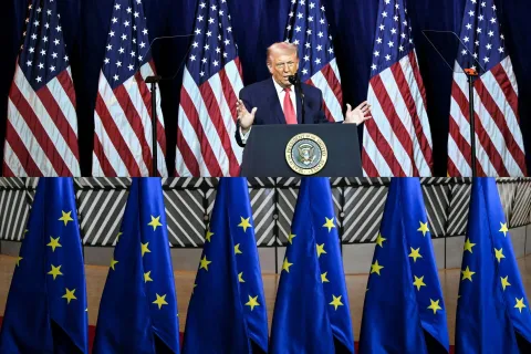 (COMBO) This combination of pictures created on January 19, 2026 shows US President Donald Trump speaking during the House Republican Party (GOP) member retreat at the Kennedy Center in Washington DC on January 6, 2026 (Top) and a photo of European Union flags in the Europa Building before a summit at the European Council in Brussels on December 18, 2024. European leaders on January 18, 2026 slammed US President Donald Trump's threat of tariffs over their opposition to his designs on Greenland, warning transatlantic ties were at risk. European countries including Denmark, of which Greenland is an autonomous territory, said they "stand united" against Trump's vow to hit them with tariffs of up to 25 percent unless Greenland is ceded to the United States. (Photo by Mandel NGAN and NICOLAS TUCAT/AFP)