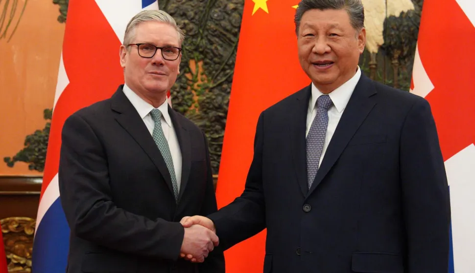 China's President Xi Jinping (R) and Britain's Prime Minister Keir Starmer shake hands before their meeting at the Great Hall of the People in Beijing on January 29, 2026. Xi told Starmer their countries must "strengthen" ties to counter geopolitical headwinds, as the leaders met in Beijing on January 29. (Photo by Carl Court/POOL/AFP)