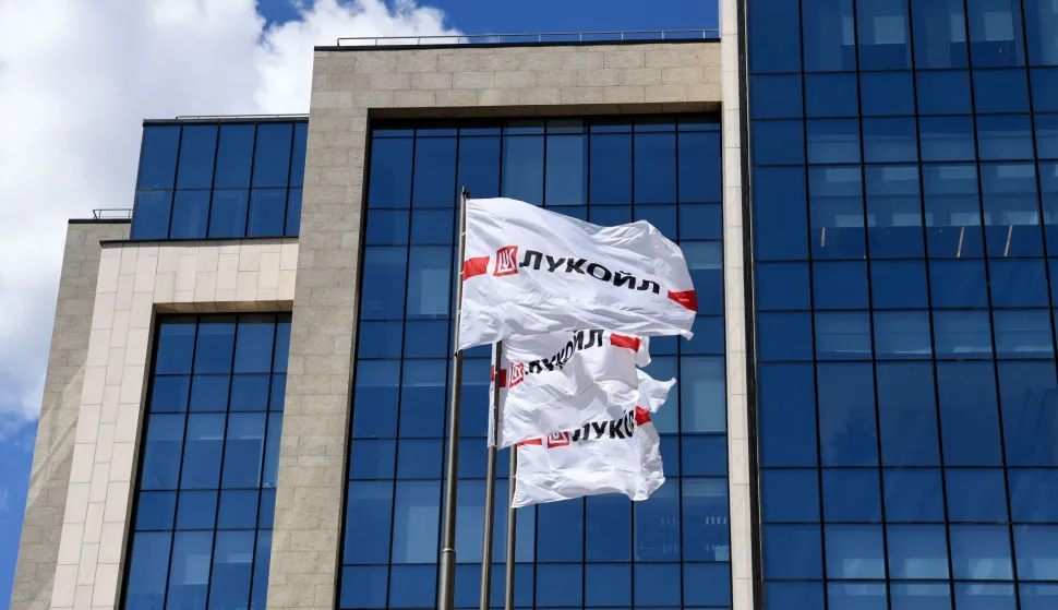 (FILES) Flags with the logo of Russia's Lukoil oil giant fly outside its headquarters in downtown Moscow on June 18, 2019. Russia's oil giant Lukoil, sanctioned by Washington over the Ukraine war, said on January 29, 2026 that it will sell its foreign assets to the US investment firm The Carlyle Group. (Photo by Kirill KUDRYAVTSEV/AFP)