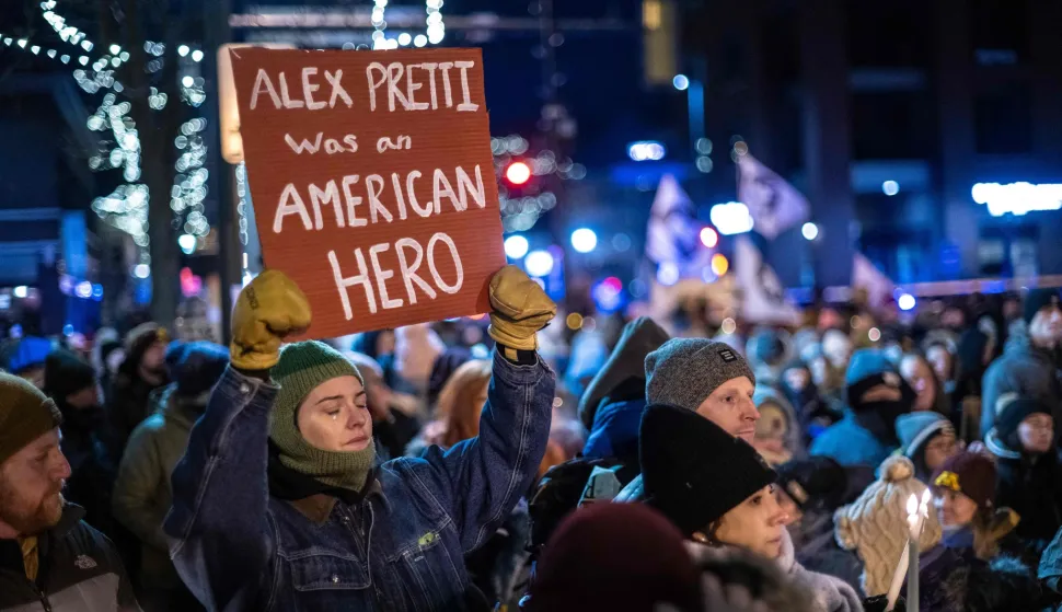 A woman sheds a tear as she holds up a placard during a candlelight vigil where 37-year-old Alex Pretti was fatally shot by immigration agents last week, in Minneapolis, Minnesota, on January 28, 2026. The Trump administration said on January 28 that two immigration agents involved in the fatal shooting of Pretti in Minneapolis had been placed on leave, as the president slammed the city?s mayor despite a promise to de-escalate the situation. The officers have been on leave -- a move US officials said was "standard protocol" -- since January 24, when Pretti was shot multiple times after being forced to the ground by camouflaged officers in a scuffle captured on video. (Photo by ROBERTO SCHMIDT/AFP)