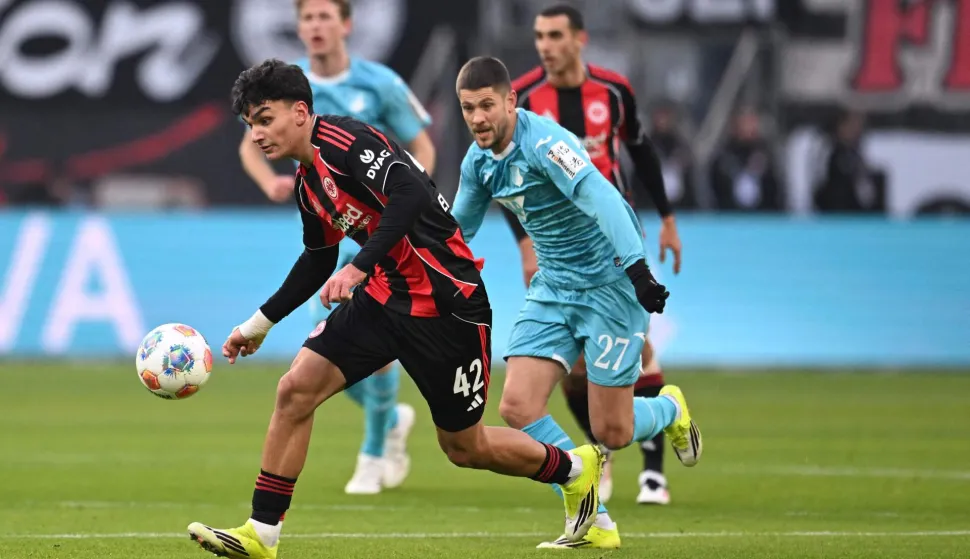 Frankfurt's Turkish forward #42 Can Uzun (L) and Hoffenheim's Croatian forward #27 Andrej Kramaric vie for the ball during the German first division Bundesliga football match between Eintracht Frankfurt and TSG 1899 Hoffenheim in Frankfurt am Main, western Germany, on January 24, 2026. (Photo by Kirill KUDRYAVTSEV/AFP)/DFL REGULATIONS PROHIBIT ANY USE OF PHOTOGRAPHS AS IMAGE SEQUENCES AND/OR QUASI-VIDEO