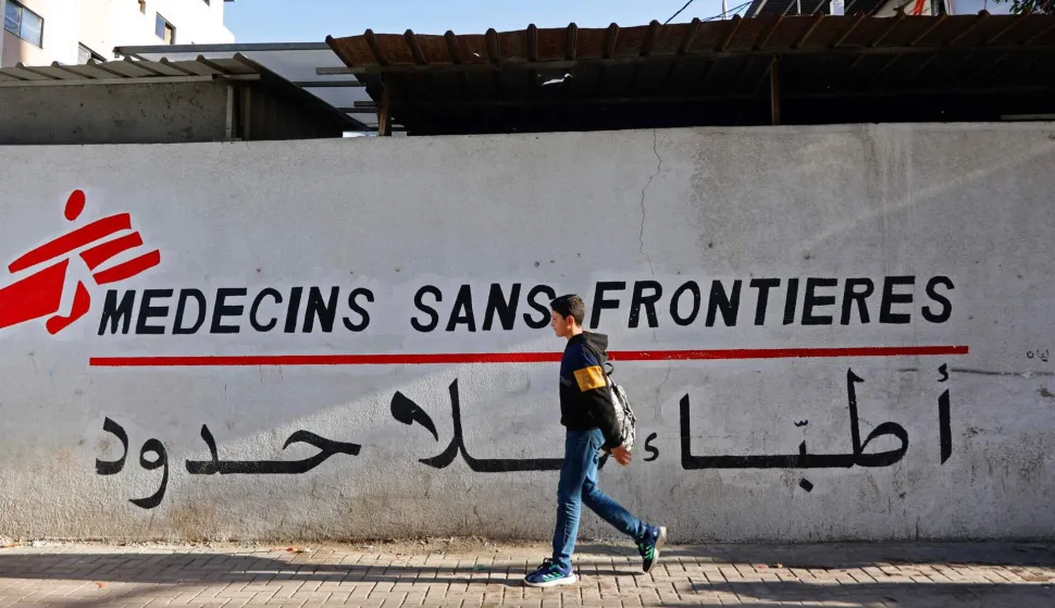 (FILES) A Palestinian boy walks past the clinic of Doctors Without Borders or Medecins Sans Frontieres (MSF), in the al-Rimal neighborhood of Gaza City on January 11, 2026. Israel said on February 1, 2026 it was terminating the humanitarian operations of the international charity Doctors Without Borders in Gaza after the organisation failed to provide a list of its Palestinian staff. (Photo by Omar AL-QATTAA/AFP)