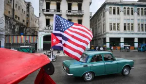 A Cuban and a US flag flutter on the roof of a tricycle in Havana on January 30, 2026. Cuban President Miguel Diaz-Canel on January 30, 2026, denounced US President Donald Trump?s attempt to ?asphyxiate? the communist island?s economy under a ?false pretext.? (Photo by YAMIL LAGE/AFP)