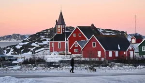 A man walks with his dog in front of a church in the city of Nuuk, western Greenland, on January 27, 2026. (Photo by Ina FASSBENDER/AFP)