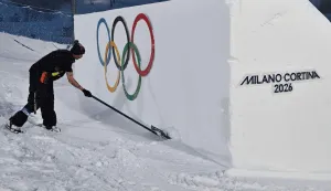 A worker shovels snow ahead of the snowboard men's big air qualifications during the Milano Cortina 2026 Winter Olympic Games at Livigno Snow Park, in Livigno (Valtellina), on February 4, 2026. (Photo by Jeff PACHOUD/AFP)