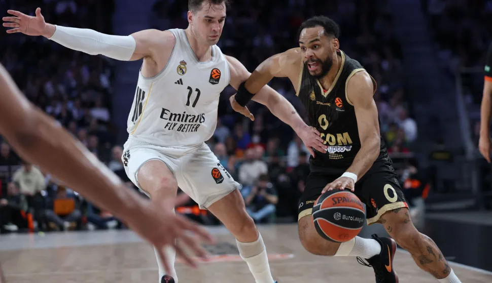 AS Monaco's French guard #00 Elie Okobo drives the ball past Real Madrid's Croatian forward #11 Mario Hezonja during the Euroleague basketball match between Real Madrid Baloncesto and Monaco at Movistar Arena in Madrid on January 22, 2026. (Photo by Thomas COEX/AFP)