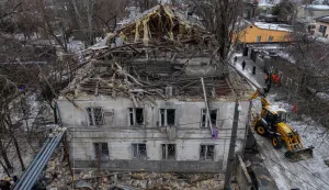 This aerial photograph shows a damaged residential building as municipal workers clean debris next to it following a Russian overnight drone attack in Odesa on February 4, 2026, amid the Russian invasion of Ukraine. (Photo by Oleksandr GIMANOV/AFP)