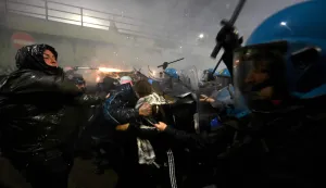 TOPSHOT - Demonstrators use fireworks against police officers during a protest against the environmental, economic and social impact of the Milano-Cortina 2026 Winter Olympics Games, in Milan on February 7, 2026. (Photo by PIERO CRUCIATTI/AFP)