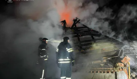 This handout photograph taken and released by the State Emergency Service of Ukraine on February 11, 2026, shows firefighters working to extinguish a fire at a private house following a Russian drone attack in Bogodukhiv Kharkiv region, amid the Russian invasion of Ukraine. A Russian drone strike on the Ukrainian city of Bogodukhiv killed three children and their father, an official said on Wednesday. A woman, identified by prosecutors as the children's mother who is eight months pregnant, was injured in the blast and sustained "a traumatic brain injury, acoustic barotrauma, and thermal burns", prosecutors said. (Photo by Handout/Ukrainian State Emergency Service/AFP)/XGTY/RESTRICTED TO EDITORIAL USE - MANDATORY CREDIT "AFP PHOTO/Ukrainian State Emergency Service" - NO MARKETING NO ADVERTISING CAMPAIGNS - DISTRIBUTED AS A SERVICE TO CLIENTS