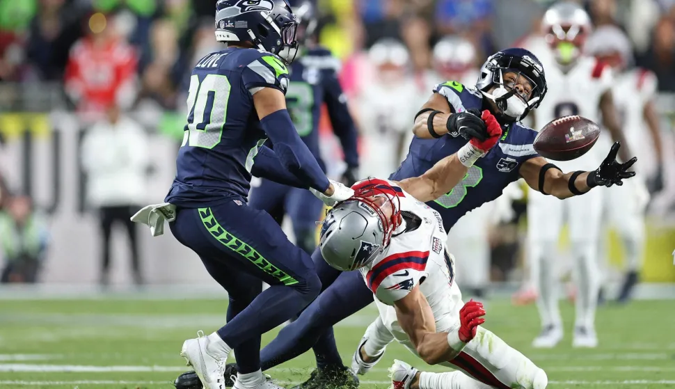 SANTA CLARA, CALIFORNIA - FEBRUARY 08: Julian Love #20 and Coby Bryant #8 of the Seattle Seahawks break up a pass intended for Mack Hollins #13 of the New England Patriots during Super Bowl LX at Levi's Stadium on February 08, 2026 in Santa Clara, California. Ronald Martinez/Getty Images/AFP (Photo by RONALD MARTINEZ/GETTY IMAGES NORTH AMERICA/Getty Images via AFP)