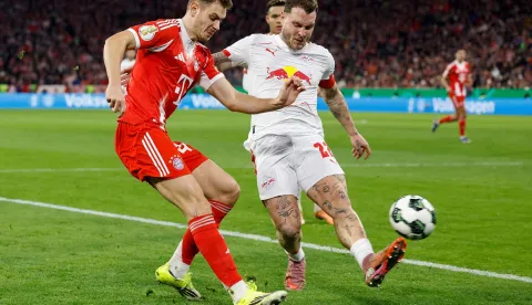 Bayern Munich's Croatian defender #44 Josip Stanisic (L) and Leipzig's German defender #22 David Raum vie for the ball during the German Cup (DFB-Pokal) quarter-final football match between FC Bayern Munich and RB Leipzig in Munich, southern Germany on February 11, 2026. (Photo by Alexandra BEIER/AFP)/DFB REGULATIONS PROHIBIT ANY USE OF PHOTOGRAPHS AS IMAGE SEQUENCES AND QUASI-VIDEO.