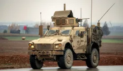 A US military mine-resistant ambush protected (MRAP) vehicle moves along a road in a convoy transporting Islamic State group detainees being transferred to Iraq from Syria, on the outskirts of Qahtaniyah in Syria's northeastern Hasakah province on February 7, 2026. Iraq's judiciary announced on February 2 that it had begun investigations into more than 1,300 Islamic State group detainees who were transferred from Syria as part of a US operation. (Photo by Delil SOULEIMAN/AFP)