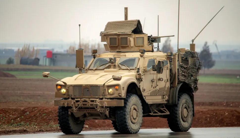 A US military mine-resistant ambush protected (MRAP) vehicle moves along a road in a convoy transporting Islamic State group detainees being transferred to Iraq from Syria, on the outskirts of Qahtaniyah in Syria's northeastern Hasakah province on February 7, 2026. Iraq's judiciary announced on February 2 that it had begun investigations into more than 1,300 Islamic State group detainees who were transferred from Syria as part of a US operation. (Photo by Delil SOULEIMAN/AFP)