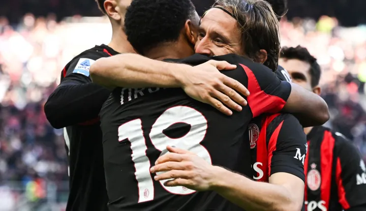AC Milan's French forward #18 Christopher Nkunku (L) celebrates with AC Milan's Croatian midfielder #14 Luka Modric (R) after scoring his team second goal during the Italian Serie A football match between AC Milan and Hellas Verona at the San Siro stadium in Milan, northern Italy, on December 28, 2025. (Photo by Piero CRUCIATTI/AFP)