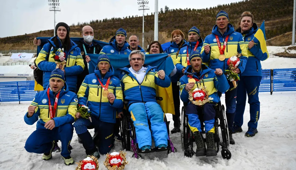 (FILES) Members of Team Ukraine gather around President of the Ukraine National Paralympic Committee Valerii Sushkevych, as they deliver a message to the press after the relay para cross-country skiing events, at The Zhangjiakou National Biathlon Centre on March 13, 2022, during the Beijing 2022 Winter Paralympic Games. The President of the Ukrainian Paralympic Committee told AFP that he feels the International Paralympic Committee (IPC) have betrayed Ukraine by permitting Russian athletes to compete under their own flag at the Milan-Cortina Games. (Photo by Lillian SUWANRUMPHA/AFP)