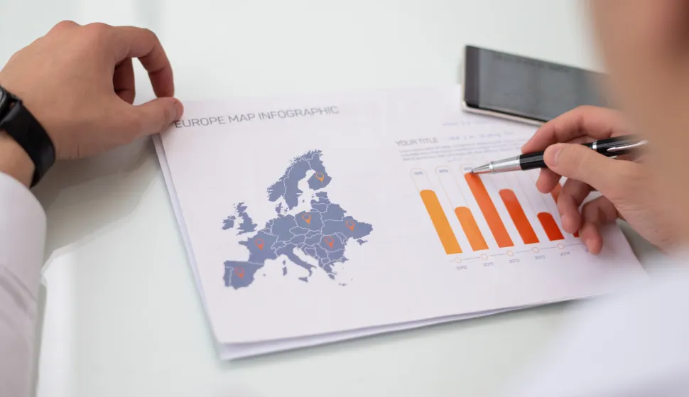 Close-up of male hands working with Europe sales statistic report. Caucasian businessman sitting at table and examining financial paper. Marketing concept