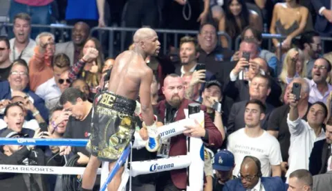 epa06165776 Floyd Mayweather (C) of the US climbs the ring ropes to celebrate his win against Conor McGregor (not pictured) of Ireland during their fight for the WBC 'Money Belt' at the T-Mobile Arena in Las Vegas, Nevada, USA, 26 August 2017. EPA/ARMANDO ARORIZO