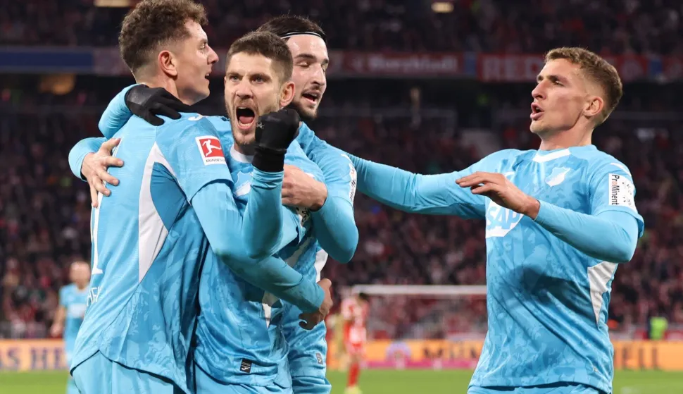 TOPSHOT - Hoffenheim's Croatian forward #27 Andrej Kramaric (2L) celebrates with teammates after scoring the equalising goal during the German first division Bundesliga football match between FC Bayern Munich and TSG 1899 Hoffenheim in Munich, southern Germany on February 8, 2026. (Photo by Alexandra BEIER/AFP)/DFL REGULATIONS PROHIBIT ANY USE OF PHOTOGRAPHS AS IMAGE SEQUENCES AND/OR QUASI-VIDEO