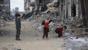Children stand on a street amid damaged buildings in Jabalia, in the northern Gaza Strip, on January 10, 2026. Since October 10, a fragile US-sponsored truce in Gaza has largely halted the fighting between Israeli forces and Hamas, but both sides have alleged frequent violations. (Photo by Bashar Taleb/AFP)