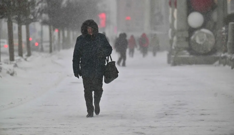 A man walks during a heavy snowfall in Moscow on February 16, 2026. (Photo by HECTOR RETAMAL/AFP)moskva, zima
