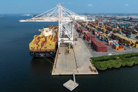 (FILES) An aerial view of a cargo ship being loaded with shipping containers at the Port of Baltimore in Baltimore, Maryland, on August 7, 2025. The US Supreme Court ruled on February 20 that Donald Trump exceeded his authority in imposing a swath of tariffs that upended global trade, blocking a key tool the president has wielded to impose his economic agenda. (Photo by Jim WATSON/AFP)