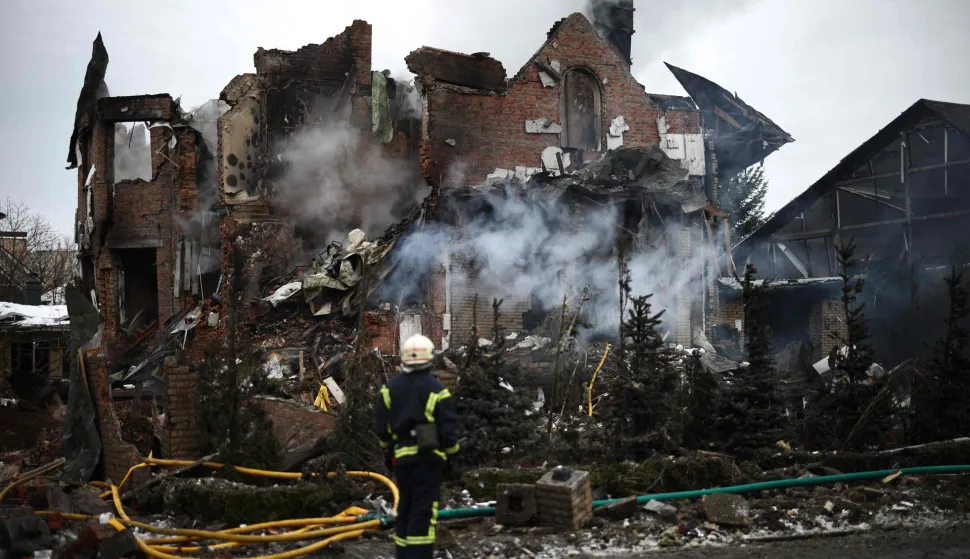 TOPSHOT - A Ukrainian rescuer stands next to a heavily damaged house following an air attack in Sofiivska Borshchagivka, Kyiv region on February 22, 2026, amid the Russian invasion of Ukraine. Explosions rocked Ukraine's capital Kyiv with officials warning of a ballistic missile attack, just two days before the fourth anniversary of Russia's invasion. (Photo by Henry NICHOLLS/AFP)