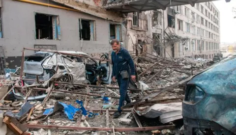 Harkiv, Ukrajina, 16.04.2022. - Stanovnik grada na jednoj od ulica uni&scaron;tenih nakon udara ruske rakete R-500 "Kalibar" u Harkivu. U toku je invazija Rusije na Ukrajinu. foto (kf) Mykola Kalyeniak/PAP