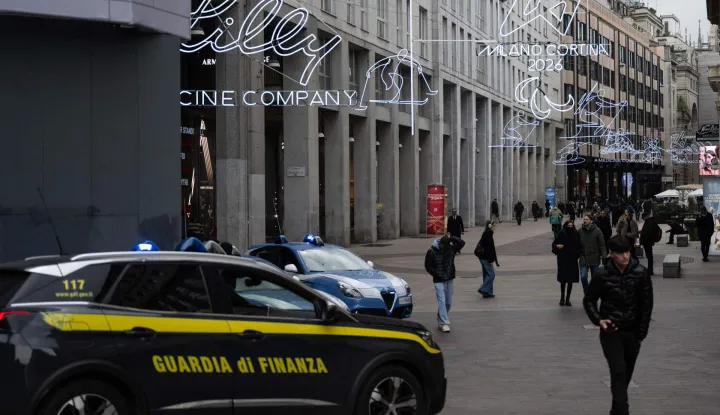 A car of the Italian Guardia di Finanza patrols in San Babila?s square ahead of Milano Cortina 2026 Olympic Games, in Milan on January 27, 2026. (Photo by MARCO BERTORELLO/AFP)