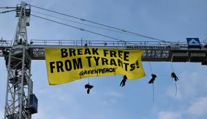 Greenpeace activists hang on a crane on which they have fixed a banner reading "Break Free From Tyrants!" near the Hotel Bayerischer Hof, venue of the Munich Security Conference (MSC) in Munich, southern Germany on February 13, 2026. Heads of state and government as well as foreign and defence ministers from all over the world are expected to attend the security policy talks from February 13 to 15, 2026. (Photo by THOMAS KIENZLE/AFP)