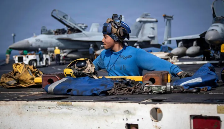 In this handout photograph taken on February 20, 2026, and released by the US Navy on February 24, 2026, US Navy Aviation Boatswain?s Mate (Handling) Airman Zyrus Rabosa operates a tractor on the flight deck of Nimitz-class aircraft carrier USS Abraham Lincoln (CVN 72), in the Arabian Sea. The United States and Israel launched strikes against Iran on February 28, with Israel's public broadcaster reporting that supreme leader Ayatollah Ali Khamenei had been targeted, as the Islamic republic retaliated with barrages of missiles at Gulf states and Israel. (Photo by Seaman Aljay Monzales/US NAVY/AFP)/RESTRICTED TO EDITORIAL USE - MANDATORY CREDIT "AFP PHOTO/U.S. Navy" - HANDOUT - NO MARKETING NO ADVERTISING CAMPAIGNS - DISTRIBUTED AS A SERVICE TO CLIENTS