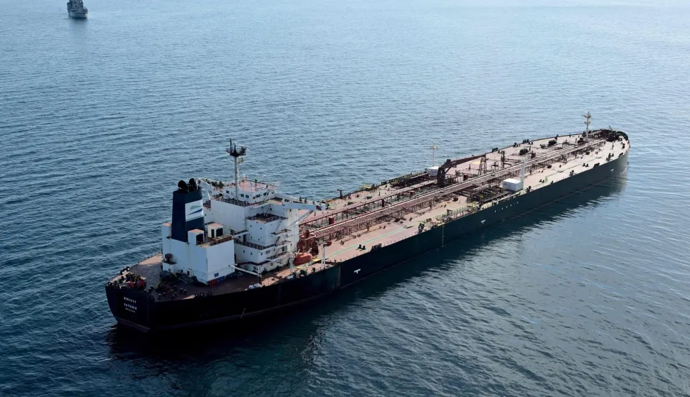 (FILES) This aerial picture taken on October 1, 2025 off the coast of the western France port of Saint-Nazaire shows the tanker Boracay from Russia's so-called "shadow fleet" suspected of being involved in drone flights over Denmark which sailed off the Danish coast between September 22 and 25, with a boat of the French Navy in the background. The Chinese captain of the Boracay tanker from Russia's so-called 'shadow fleet' intercepted off the French coast, will stand trial at Brest courthouse, western France, on February 23, 2026. (Photo by Damien MEYER/AFP)