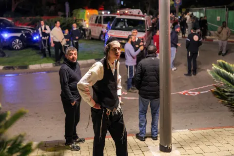 People gather near ambulances and first responders outside a building where an accidental fire was reported in Tel Aviv on March 1, 2026. The United States and Israel launched strikes against Iran on February 28, killing Iran's supreme leader and top military leaders, prompting authorities to retaliate with strikes on Israel and US bases across the Gulf. (Photo by Ilia YEFIMOVICH/AFP)