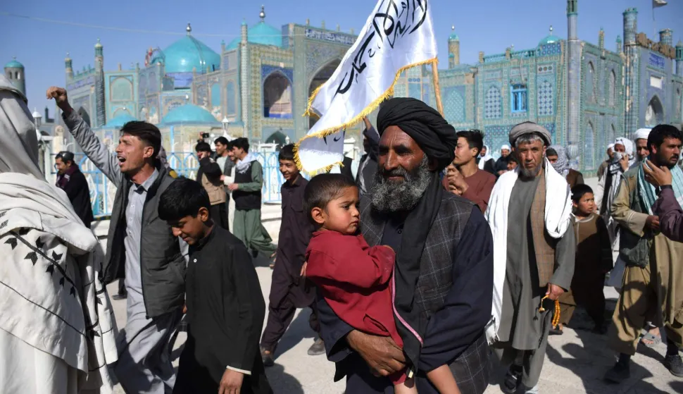 TOPSHOT - Afghan supporters gather to cheer for Taliban security personnel at the Hazrat-e-Ali Shrine, or the Blue Mosque in Mazar-i-Sharif on March 1, 2026 amid ongoing cross-border fighting between Pakistan and Afghanistan. Explosions were heard in the Afghan capital Kabul on March 1, AFP journalists said, with the Taliban government saying they were responding to aerial Pakistan attacks. (Photo by AFP)