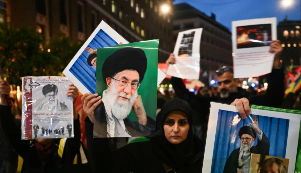 People hold pictures of assassinated Iranian supreme leader Ayatollah Ali Khamenei and Iranian flags during a protest against the US and Israel attack of Iran near the US Embassy in Rome, on March 3, 2026. The United States and Israel launched strikes against Iran on February 28, killing Iran's supreme leader and top military leaders, prompting authorities to retaliate with strikes on Israel and across the Gulf. (Photo by Alberto PIZZOLI/AFP)