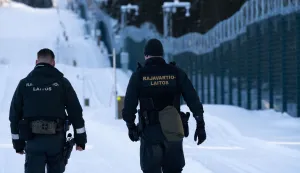 Finnish border guards walk along the newly built fence at the border between Finland and Russia in Tohmajarvi, Finland, on February 4, 2026 (Photo by Alessandro RAMPAZZO/AFP)