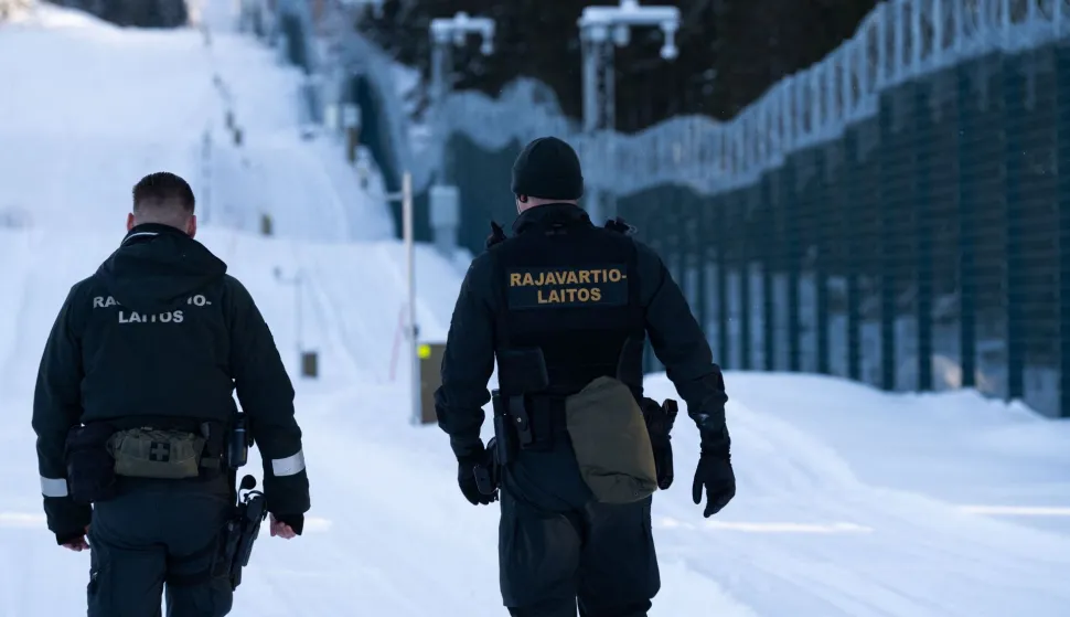 Finnish border guards walk along the newly built fence at the border between Finland and Russia in Tohmajarvi, Finland, on February 4, 2026 (Photo by Alessandro RAMPAZZO/AFP)