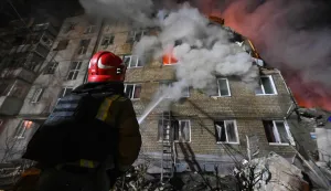 A firefighter extinguishes a blaze at a five-story residential building in Kharkiv on March 7, 2026, after it was partially destroyed by a Russian strike amid the Russian invasion of Ukraine. Ukraine issued a nationwide air alert early on March 7, as Russian strikes wounded 10 people in the Kharkiv region, authorities said. Kharkiv regional military chief Oleg Synegubov said at least three people were treated in hospital, including an 11-year-old boy, after a strike on a residential building. (Photo by SERGEY BOBOK/AFP)