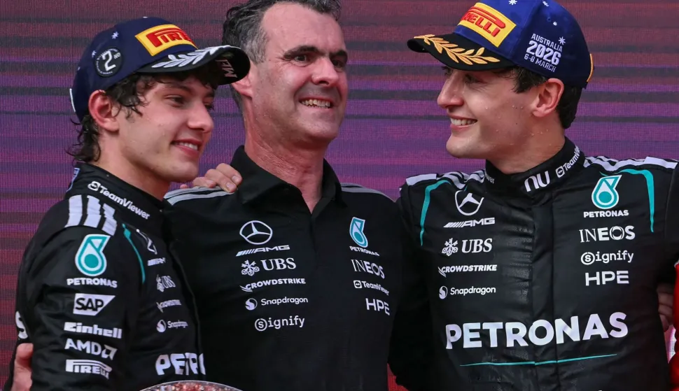 TOPSHOT - First-placed Mercedes' British driver George Russell (R) celebrates on the podium with second-placed Mercedes' Italian driver Kimi Antonelli (L) and Hywel Thomas (C), managing director of Mercedes AMG High Performance Powertrains, after the Formula One Australian Grand Prix at the Albert Park Circuit in Melbourne on March 8, 2026. (Photo by WILLIAM WEST/AFP)/-- IMAGE RESTRICTED TO EDITORIAL USE - STRICTLY NO COMMERCIAL USE --