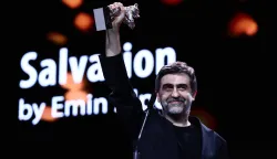21 February 2026, Berlin: Emin Alper receives the Silver Bear Grand Jury Prize for the film "Kurtulus (Salvation) " on stage during the award ceremony at the closing gala in the Berlinale Palast. The 76th Berlin International Film Festival will take place from February 12 to 22, 2026. Photo: Christoph Soeder/dpa Photo: Christoph Soeder/DPA